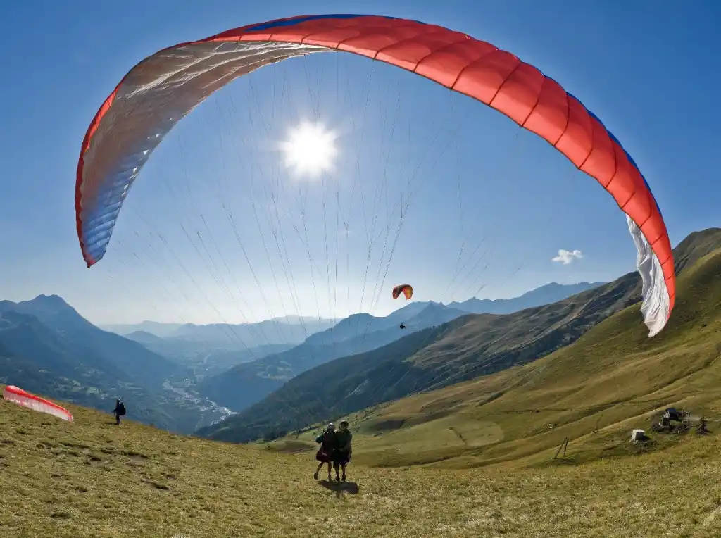 A paraglider flying over Rishikesh with panoramic Himalayan views